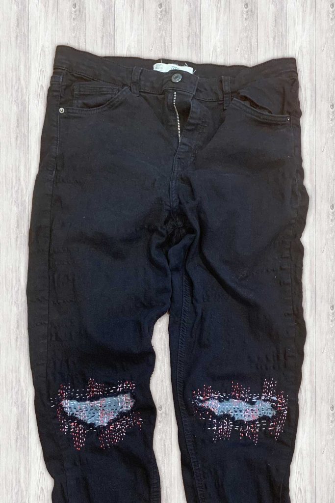 black jeans with embroidered running stitch patches