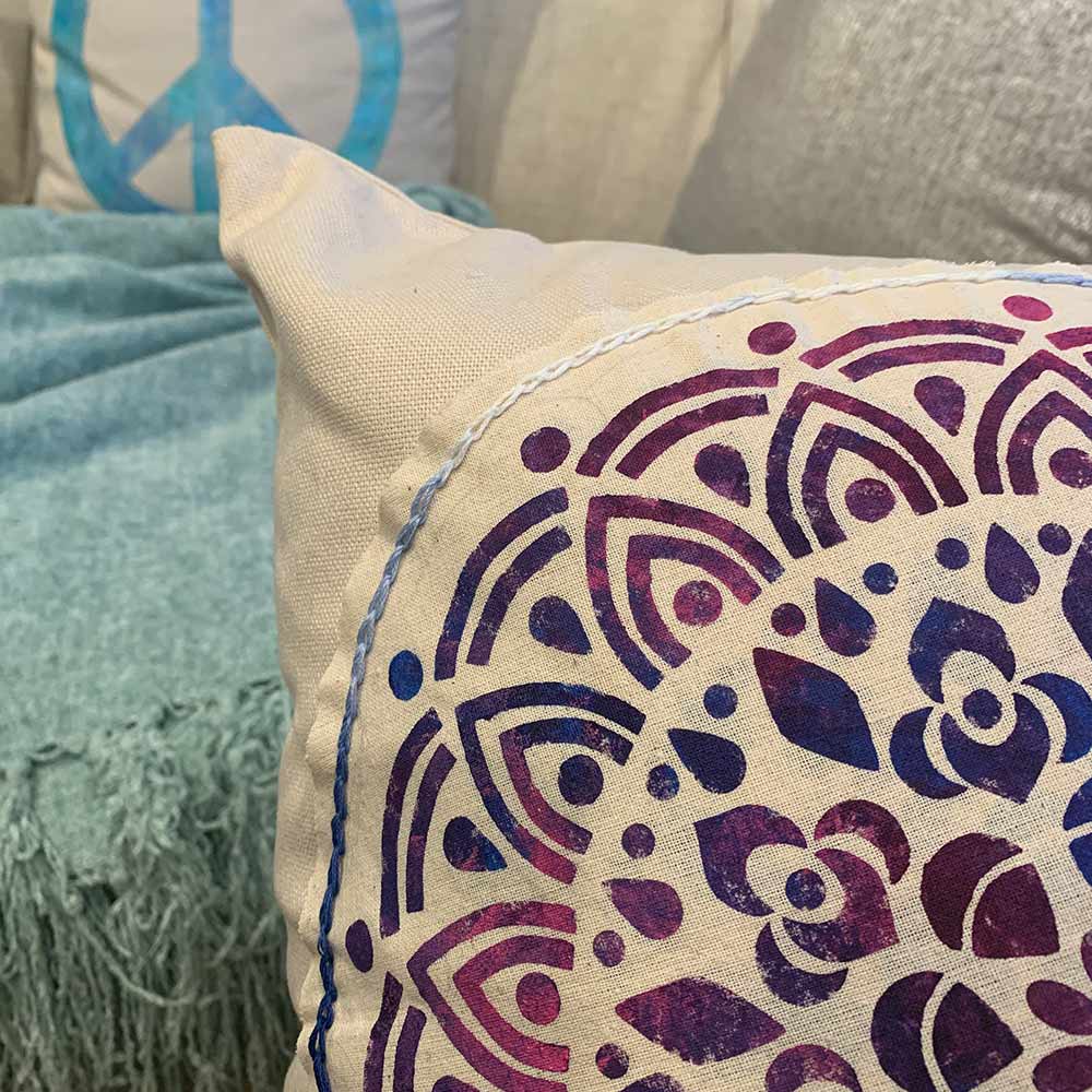 corner of stenciled medallion pillow qith appliqued design