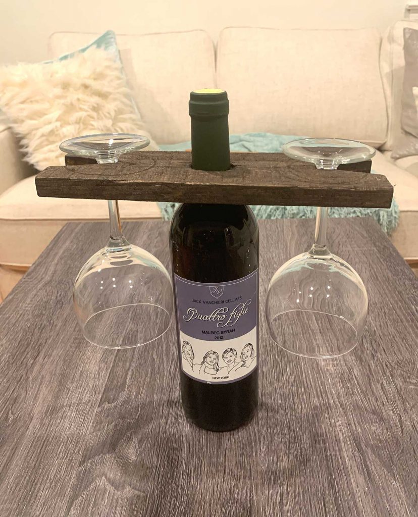 Wood pallet wine holder with bottle of wine and wine glasses on a table