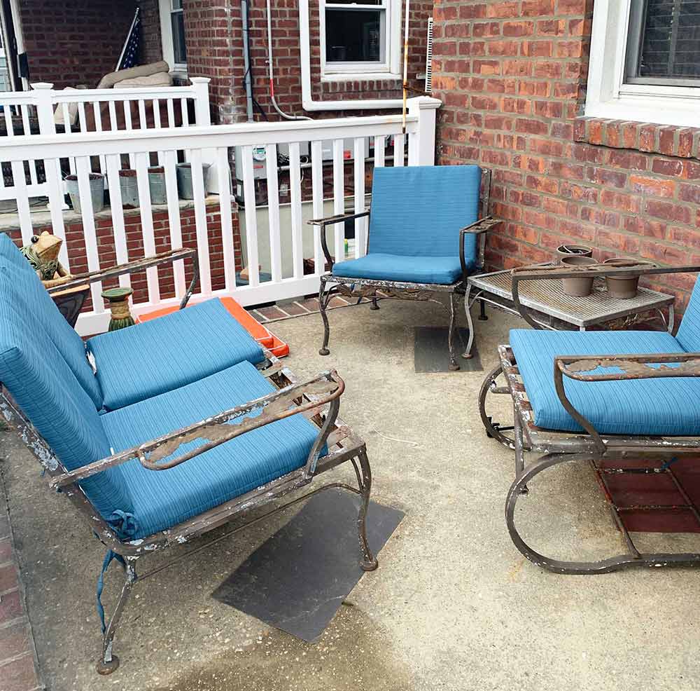 old metal patio set before painted with old blue cushions