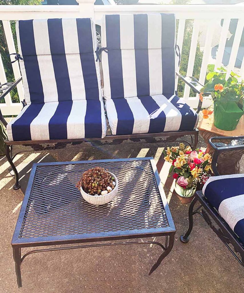 painted metal patio set with blue and white cushions