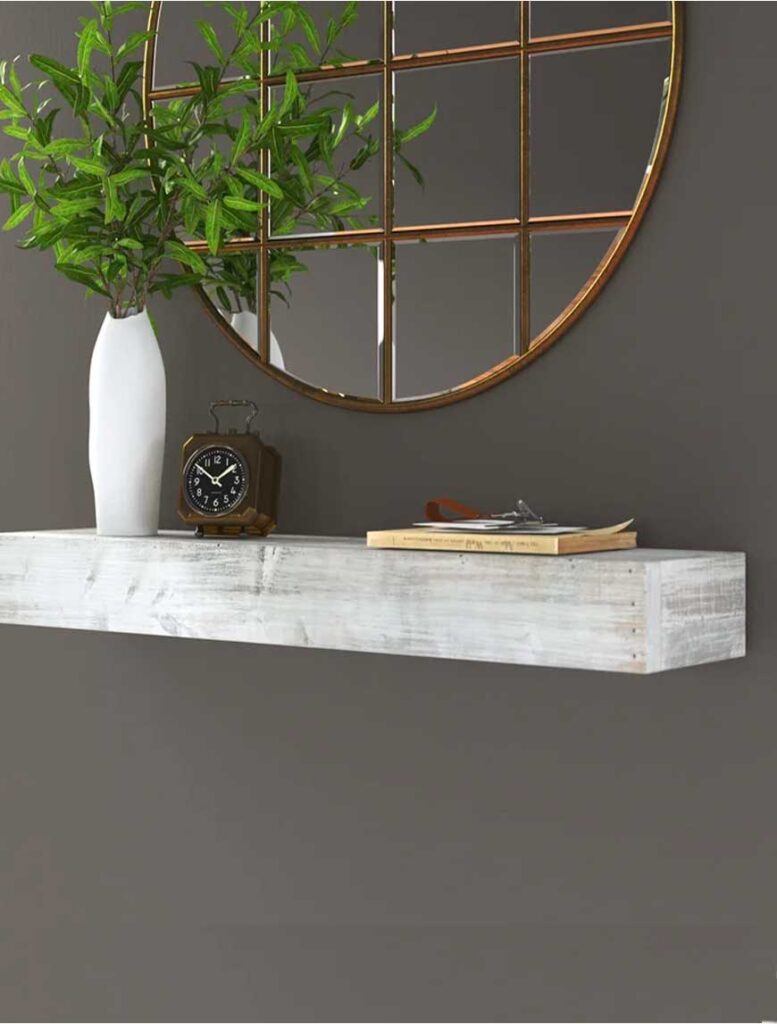 White washed floating shelf with large round mirror, vase and clock