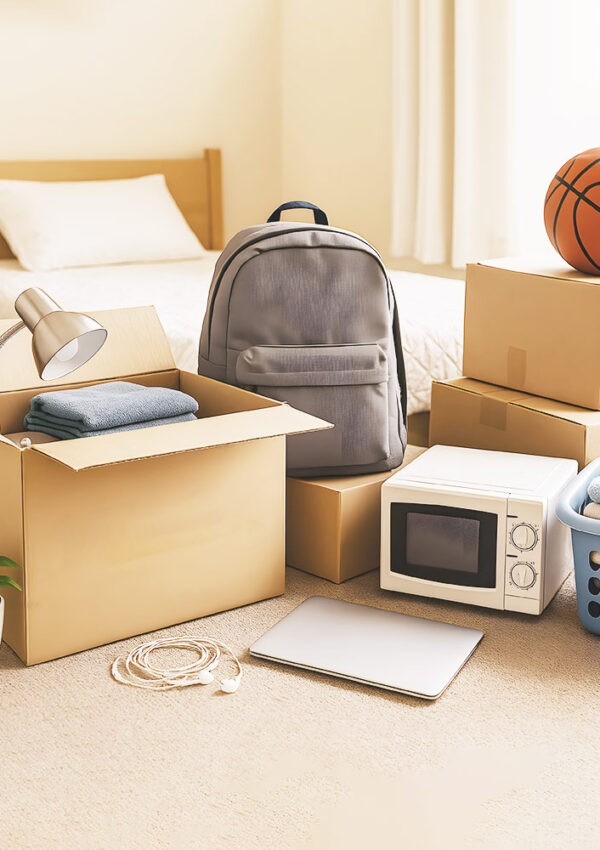 college guy dorm room with move in boxes, backpack, lamp, basketball , laundry and microwave