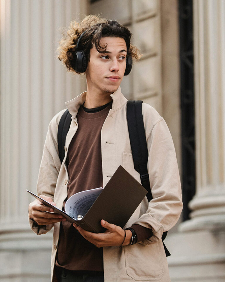 college guy with headphones and binder
