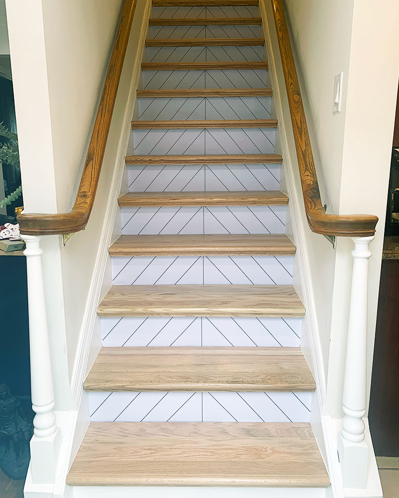 staircase makeover with new oak stairs and peek and stick wallpaper on risers.