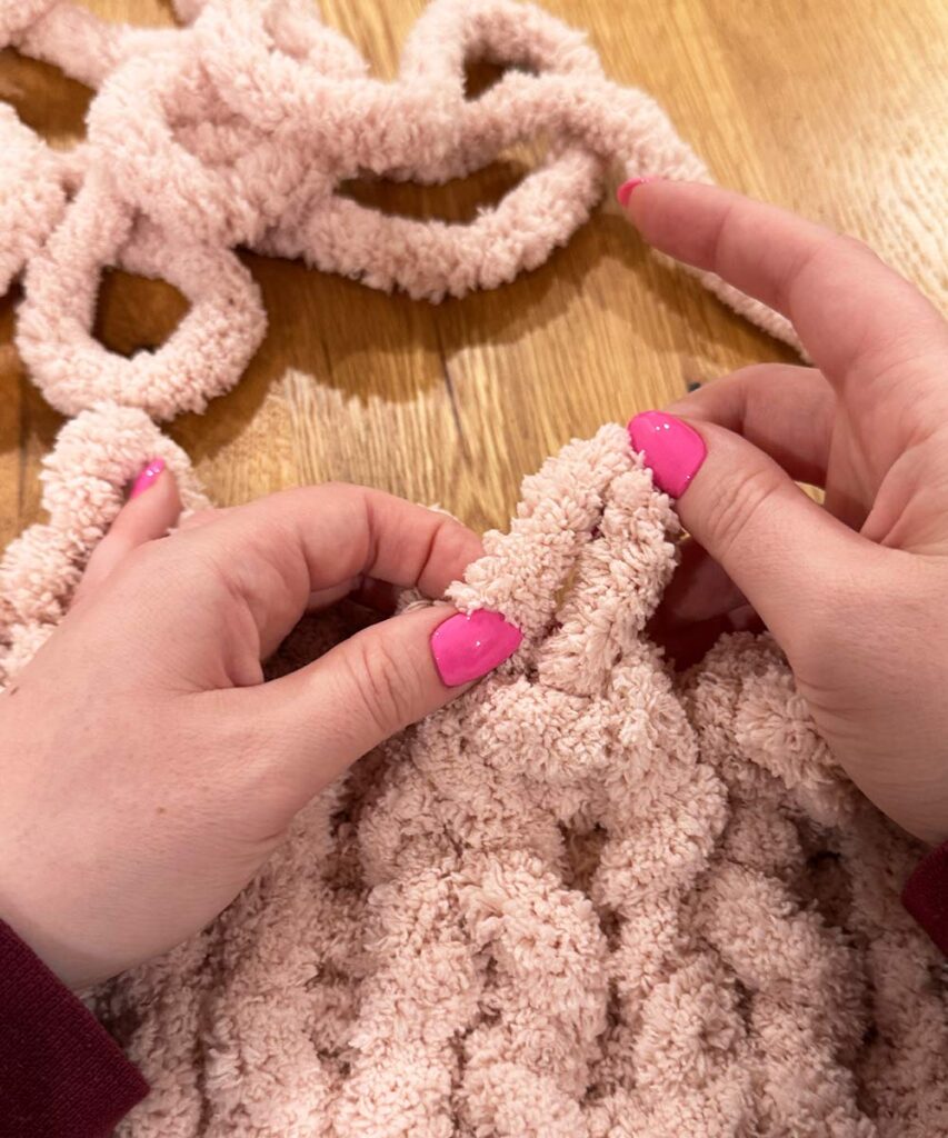 using a loop to knit yarn through to create a stitch