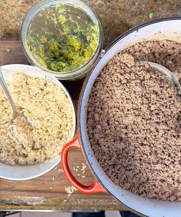 ingredients for diy dog food toppers cooked meat, brown rice and minced vegetables all in containers